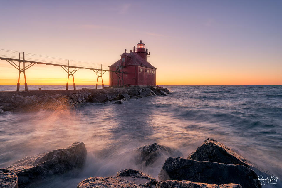 Sturgeon bay ship canal pierced lighthouse at sunrise with the smashing waves of Lake Superior.