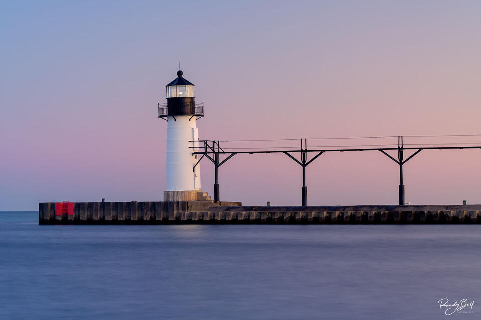 St. Joseph north pier outer lighthouse bathed in the soft light of sunrise during a long exposure image